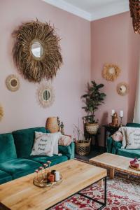 a living room with green couches and a table at BOHO HOUSE in Ustrzyki Dolne