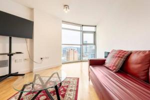 un soggiorno con divano rosso e tavolo in vetro di Cardiff city apartment 2 a Cardiff