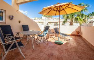 eine Terrasse mit Tisch und Stühlen und einem Sonnenschirm in der Unterkunft 2 Bedroom Nice Home In La Florida in La Florida
