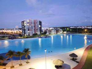 a large swimming pool with palm trees and buildings at Come to Paradise an be our Guest in Dream Cancun!! in Cancún