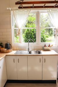 cocina con fregadero y ventana en The Old Cottage - Country Couples Retreat en Tomerong
