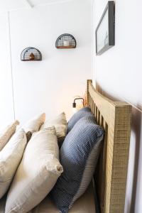 ein Stapel Kissen auf einem Bett in der Unterkunft The Old Cottage - Country Couples Retreat in Tomerong