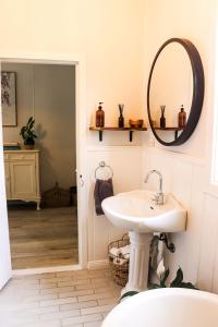 uma casa de banho com um lavatório e um espelho em The Old Cottage - Country Couples Retreat em Tomerong
