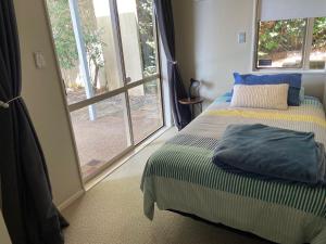 1 dormitorio con cama y ventana grande en Homestay free breakfast Close Motorway, en Auckland