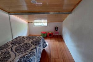 ein Schlafzimmer mit einem Bett in einem Zimmer mit einem Fenster in der Unterkunft Villa El Sol in Jardín