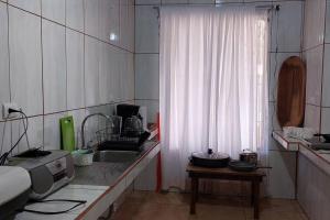 a kitchen with a sink and a table with a microwave at Villa El Sol in Jardín