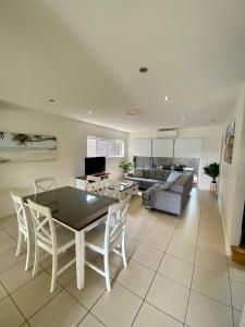 ein Wohnzimmer mit einem Tisch, Stühlen und einem Sofa in der Unterkunft Quarterdecks Retreat in Hervey Bay