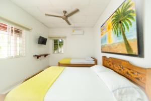 een slaapkamer met een bed en een schilderij aan de muur bij Hostal del Mar - Tolu in Tolú