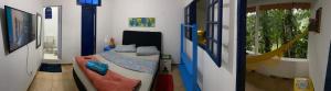 Habitación con dormitorio con cama y ventana en ÓTIMA NOTA - CASA DO RIO DE PEDRAS Próximo Praias , Ilhas ,Cachoeiras e Centro Histórico, en Paraty