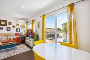 a living room with a table and a large window at Entire Modern 3-Bedroom Home with Balcony Views near San Diego Gaslamp, 10 Guests Maximum in National City