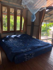 Cama en habitación con edredón azul en The Big House, en Koh Chang