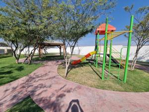 a playground with a slide in a park at Casa muy Ubicada Amplia con alberca Montejo SD in Querétaro