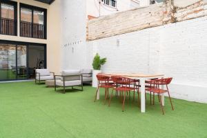 a table and chairs on a green floor at Stay U-nique Apartments Albeniz BCN in Hospitalet de Llobregat