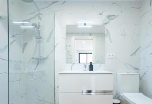 une salle de bain blanche avec une douche et un lavabo dans l'établissement Stay U-nique Apartments Albeniz BCN, à L'Hospitalet de Llobregat 103 autres photos