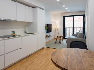 cocina y sala de estar con mesa en Stay U-nique Apartments Albeniz BCN, en Hospitalet de Llobregat