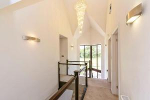 a staircase in a house with a chandelier at The Pines in Saint Leonards