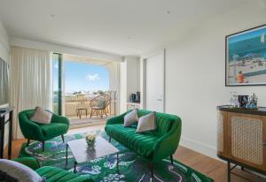 a living room with a green couch and a table at InterContinental Sorrento Mornington Peninsula in Sorrento