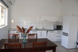 uma cozinha com uma mesa com cadeiras e um frigorífico em Casa Ofori em Willemstad