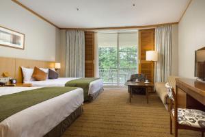 a hotel room with two beds and a balcony at The Prince Hakone Lake Ashinoko in Hakone