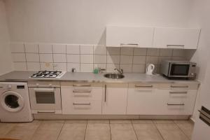 a kitchen with a sink and a stove and a microwave at Casa Ofori in Willemstad