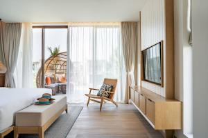 a hotel room with a bed and a tv at The Ocean Resort Quy Nhon by fusion in Quy Nhon