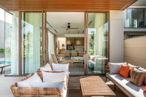 an open living room with glass doors and furniture at The Ocean Resort Quy Nhon by fusion in Quy Nhon