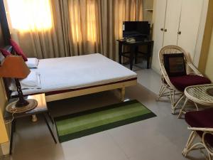 a bedroom with a bed and two chairs and a desk at Mewar Inn in Udaipur