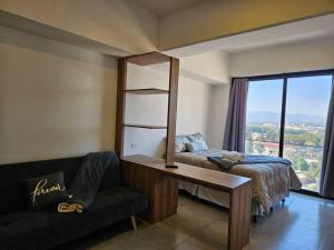 ein Schlafzimmer mit einem Bett, einem Tisch und einem Sofa in der Unterkunft Apartamento Cerca del Aeropuerto in Guatemala