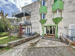 um edifício com acentos verdes na lateral em Studio Lamalou-les-Bains, 1 pièce, 2 personnes - FR-1-451-67 em Lamalou-les-Bains