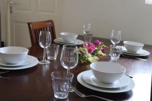 威廉斯塔德的住宿－Casa Ofori，一张木桌,上面有盘子和杯子,上面有眼镜