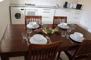 uma mesa de jantar com cadeiras, pratos e copos em Casa Ofori em Willemstad