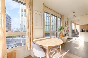 a dining room with a table and a large window at Résidor - Beautiful appartment 2P in Paris