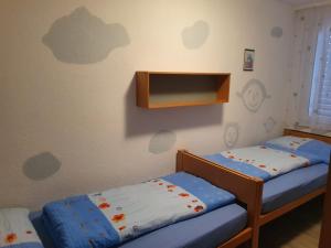 a room with two beds and a tv on the wall at Elfe - Apartments Three-bedroom Apartment for 6 guests with patio in Emmetten +19 photos