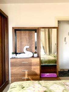 ein Schlafzimmer mit einem Spiegel mit einem Schwan in der Unterkunft Grand Madinaty Couzy Home in Madinaty