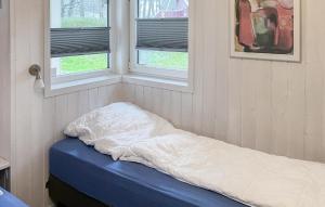 Bett in einem Zimmer mit zwei Fenstern in der Unterkunft Schmugglerstieg 7 - Dorf 6 in Travemünde