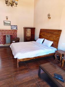 a bedroom with a large bed and a table at Heritage Inn by Brown Tree Resorts in Ooty
