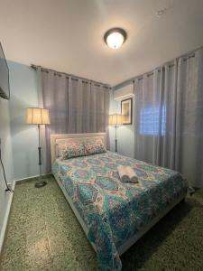 1 dormitorio con 1 cama, 2 lámparas y ventana en Casa Laguna Unit 6, Spacious 3BR Near Beach and Restuarants, en San Juan