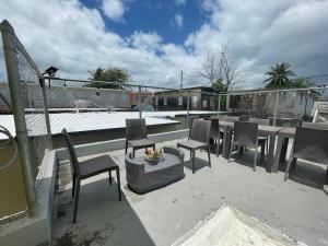 Un patio con sillas y una mesa en el balcón. en Casa Laguna Unit 6, Spacious 3BR Near Beach and Restuarants, en San Juan