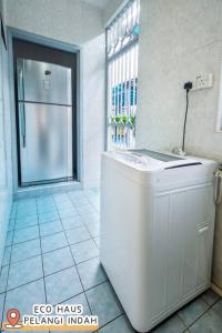 a white bathroom with a refrigerator and a window at ECOHAUs AeonTebrau/Pool/Netflix/Karaoke/Gaming in Ulu Tiram