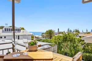 a balcony with a table and a view of the ocean at Quaint 2-Bed Beach Abode with Ocean Views in Alexandra Headland