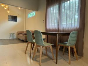 - une salle à manger avec une table et quatre chaises dans l'établissement Two bedroom Villa Mango, à Ko Pha Ngan