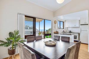 a kitchen and dining room with a table and chairs at Quaint 2-Bed Beach Abode with Ocean Views in Alexandra Headland