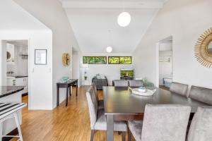 a dining room and living room with a table and chairs at Quaint 2-Bed Beach Abode with Ocean Views in Alexandra Headland