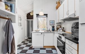 a kitchen with white cabinets and a checkered floor at Holiday Home Fasanvej Xii in Humble