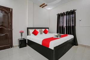 1 dormitorio con 1 cama grande con almohadas rojas en Flagship Hotel Ay Imperial en Nagpur