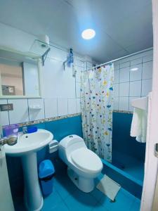 een blauwe badkamer met een toilet en een wastafel bij Casa de Playa Arena & Mar in Barranca