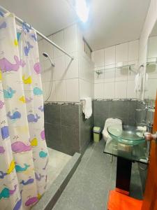 een badkamer met een douche, een wastafel en een toilet bij Casa de Playa Arena & Mar in Barranca