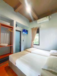 a bedroom with two beds and a window at Degung Hillside in Bogor