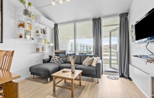 3 Bedroom Awesome Apartment In Ringkbing في رينكوبنج: غرفة معيشة مع أريكة وطاولة