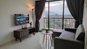 a living room with a couch and a large window at Horizon Delux Suite @ Ipoh Town in Ipoh